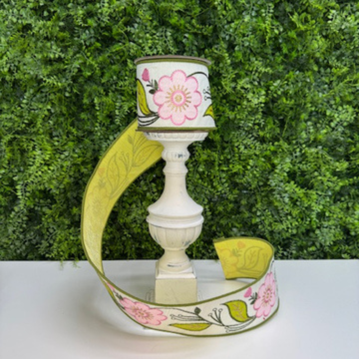 Decorative Farrisilk ribbon with a floral design on a white surface against a green leafy background