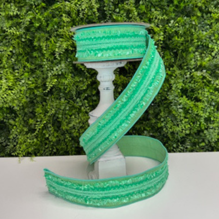 Mint Green ribbon  on a white stand against a green leafy background