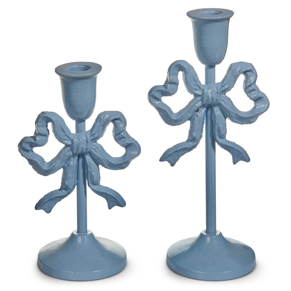 Two blue candle holders with bow designs on a white background