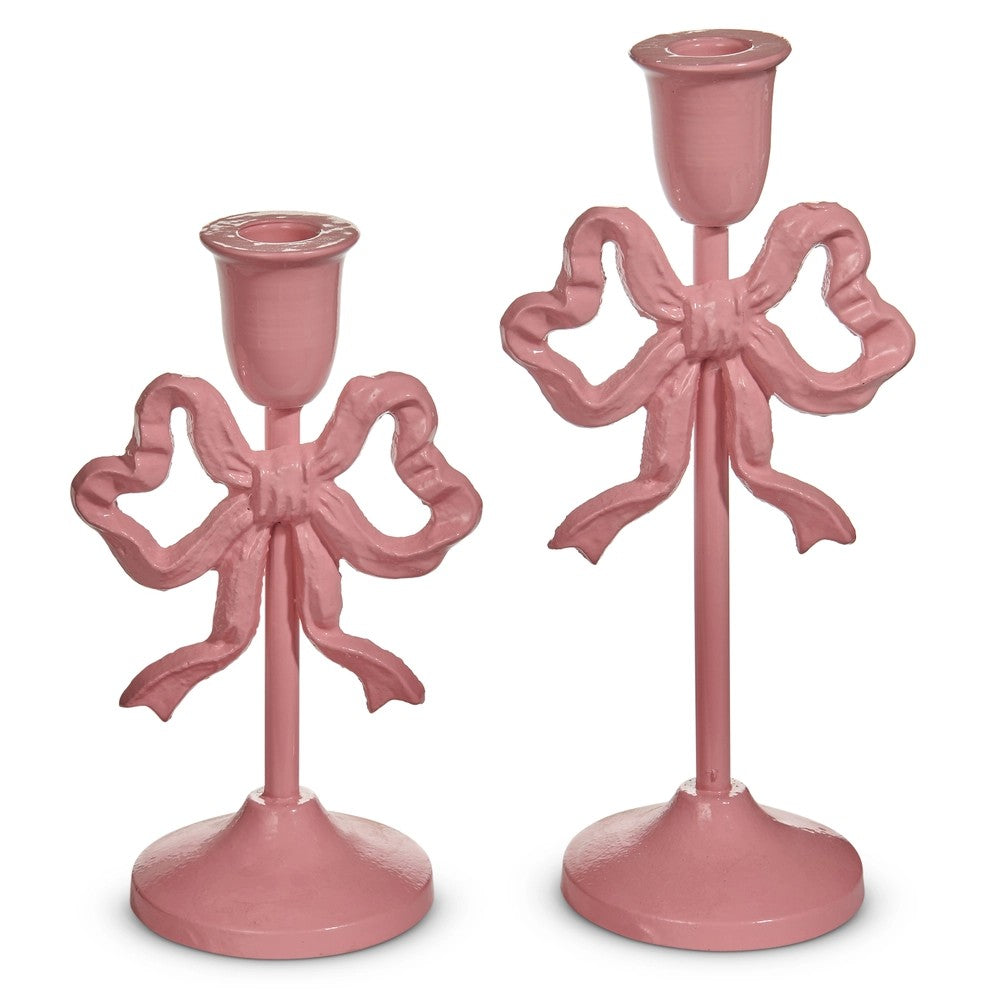 Two pink bow-shaped candle holders on a white background