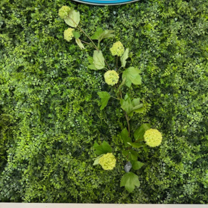 Artificial green bush with green flowers on a green background