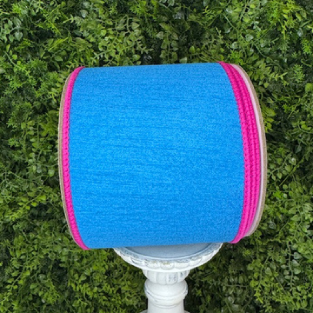 Blue and pink wired ribbont on a white stand against a green grass background
