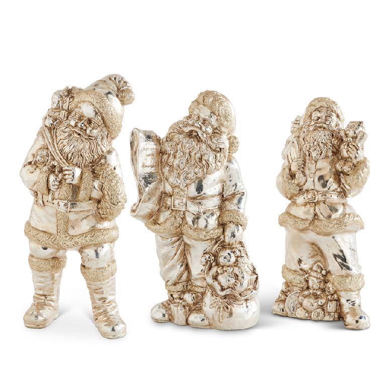 Three decorative figurines of santas in a metallic finish on a white background