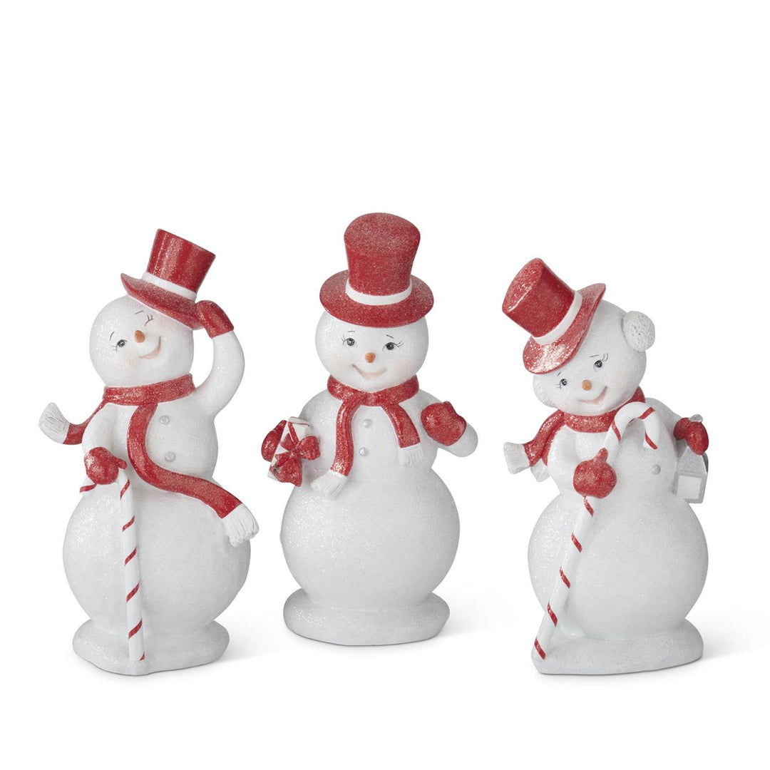 Three snowman figurines with red hats and scarves on a white background