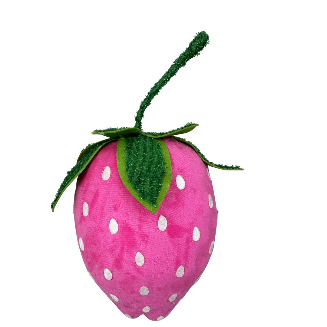 Pink strawberry-shaped plush toy with white polka dots on a white background