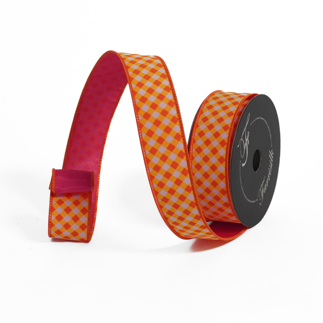 Spool of orange and white checkered ribbon with a pink border on a white background