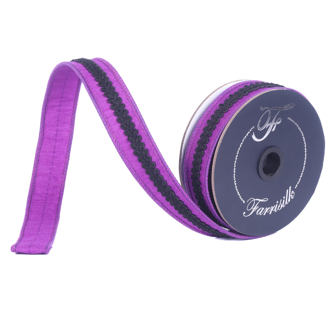 Spool of purple ribbon with black stripe on a white background