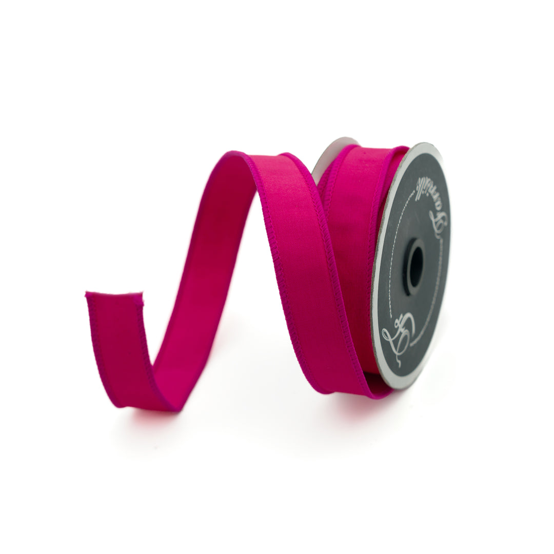 Spool of pink ribbon on a white background