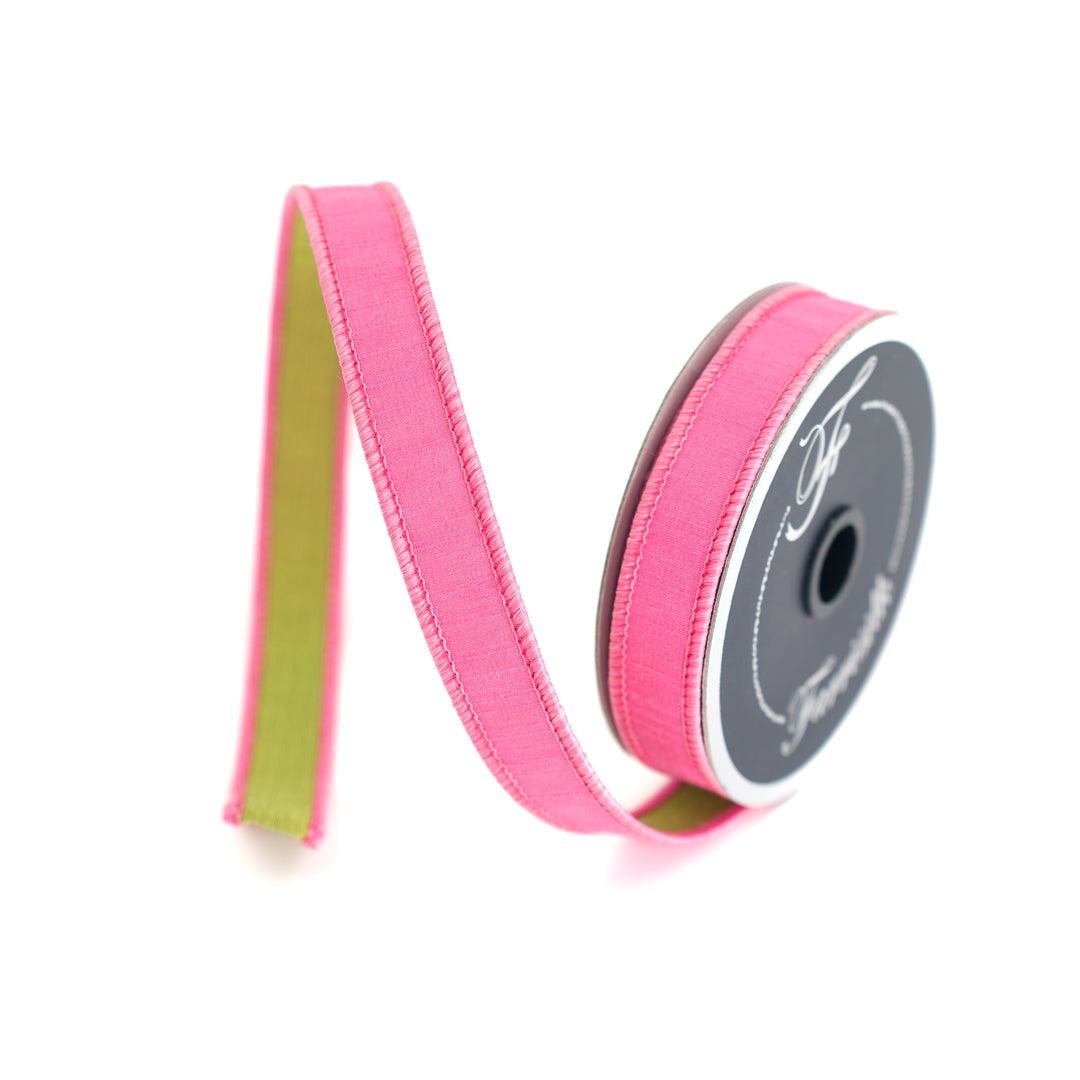 Pink ribbon with a spool on a white background