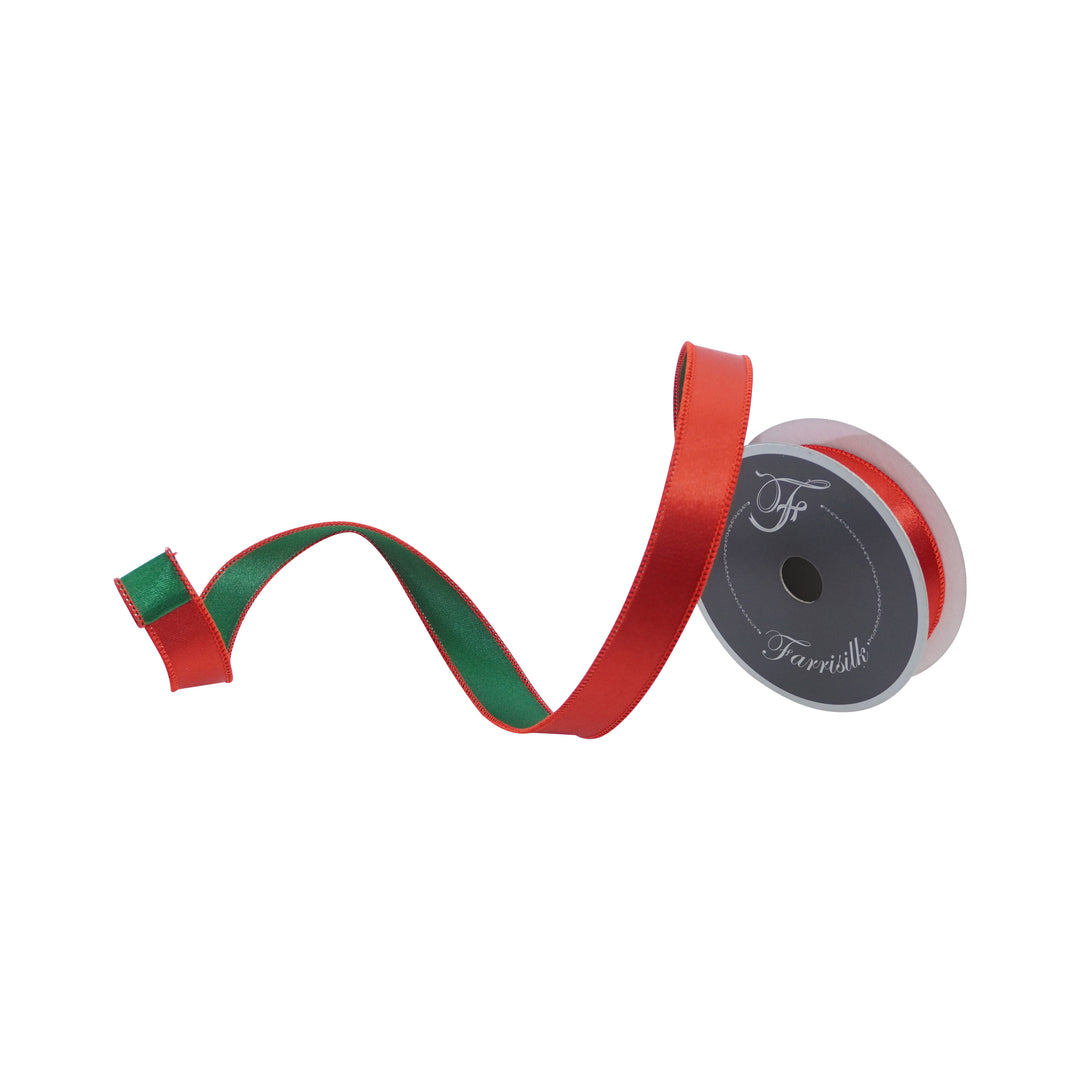 Red and green ribbon with a spool on a white background