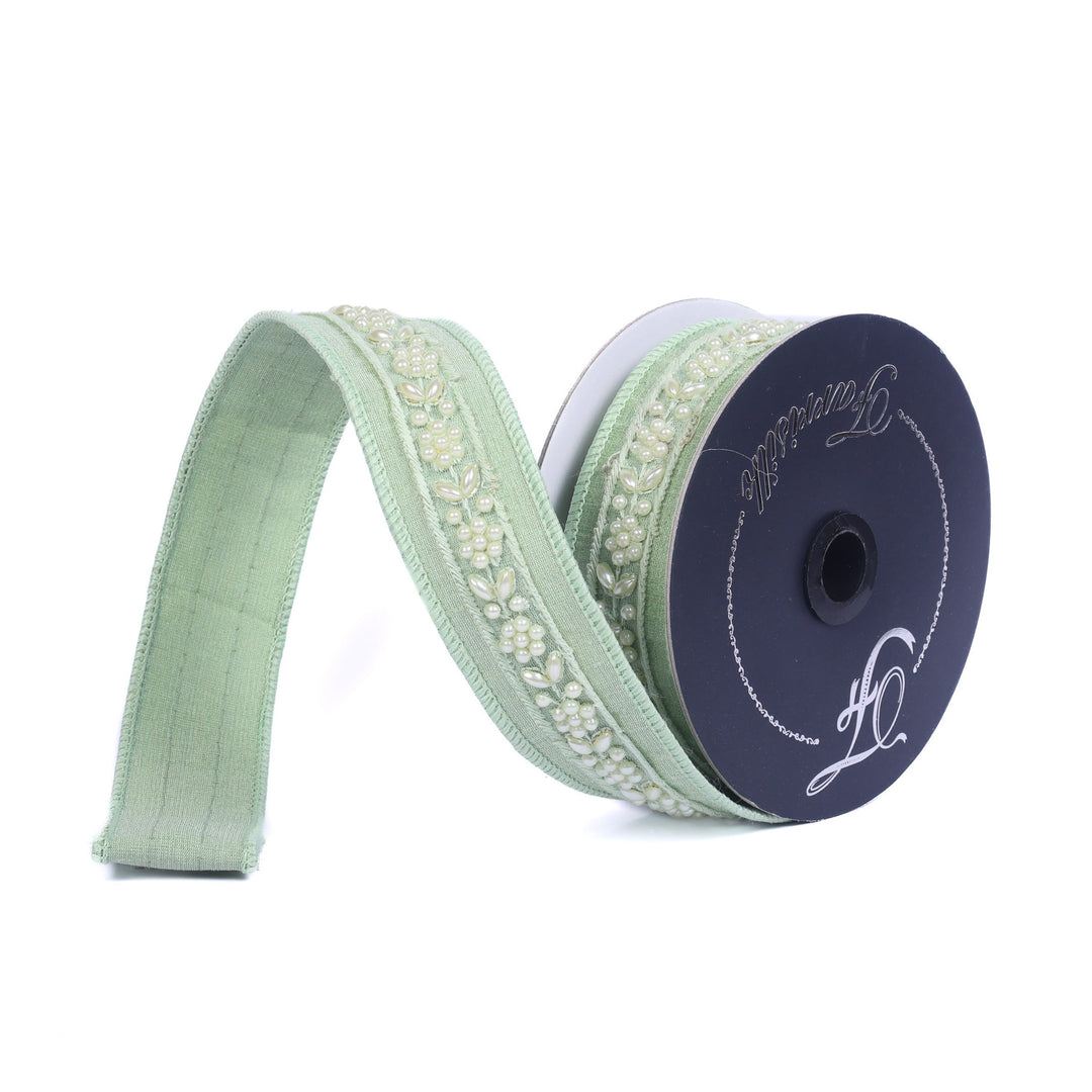 Spool of light green ribbon with decorative edge on a white background