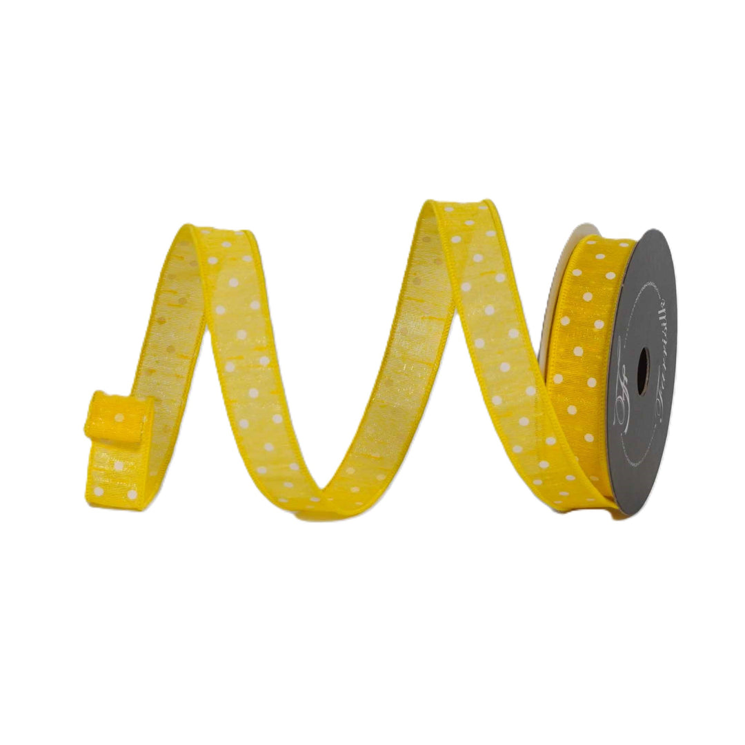 Yellow ribbon with white polka dots on a spool against a white background