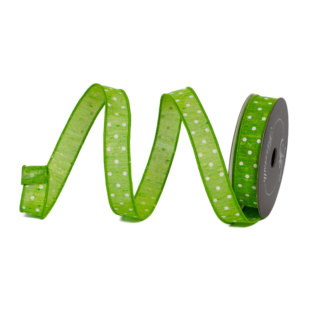 Green ribbon with white polka dots on a spool against a white background